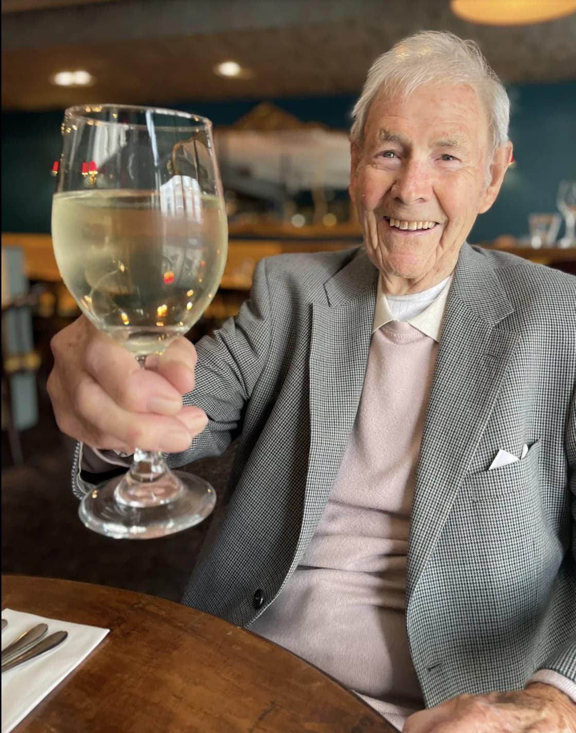 The grandad whose conversations inspired Carbery, smiling and raising a glass at a family meal.
